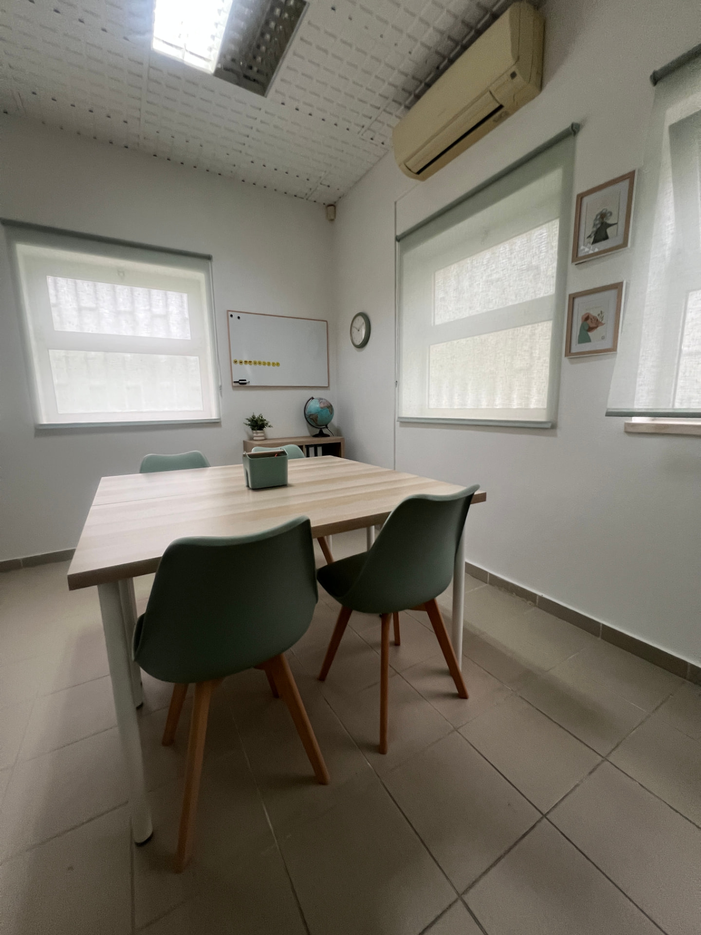 Sala com mesa de grupo, quadro branco e globo